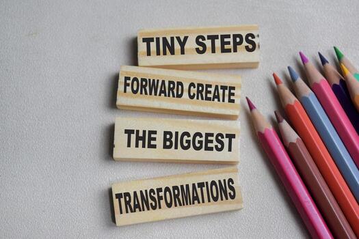 Tiny steps forward create the biggest transformations on stacked wooden cubes on the table. Business and finance concept photo
