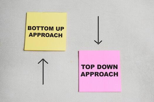 Concept of bottom up approach and top down approach write on sticky notes isolated on Wooden Table. photo