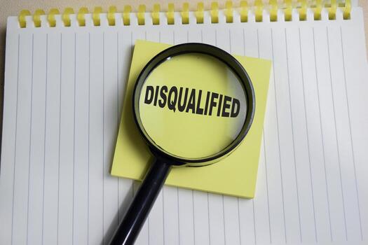 Concept of disqualified write on sticky notes isolated on Wooden Table. photo