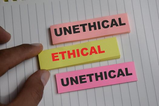 Concept of ethical or unethical write on sticky notes isolated on Wooden Table. photo