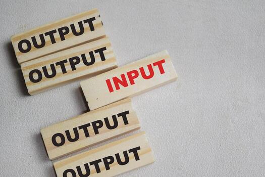 Two words input or output. Choose input on stacked wooden cubes on the table. Business and finance concept photo