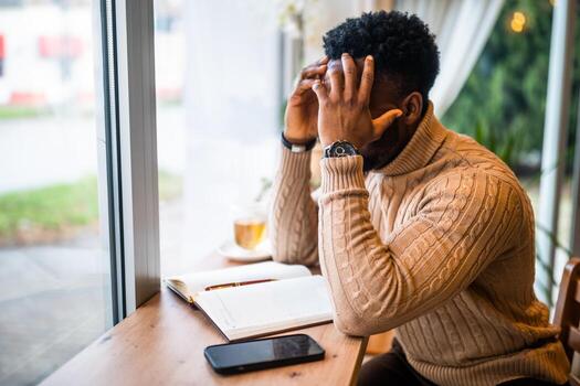 Freelancer struggling with stress while checking messages and planning projects on mobile and notepad. photo