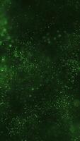 brillante luccicante particelle e scintillante bokeh leggero su un' buio verde pendenza sfondo. sfarzoso luccichio celebrazione festa animazione. adatto come un astratto santo Patrick giorno verticale sfondo. video