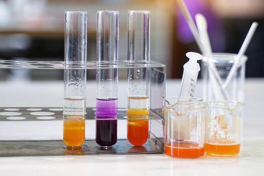 A rack holds three test tubes with colorful liquids indicating to Shows experimental results on DNA extraction from various fruits photo