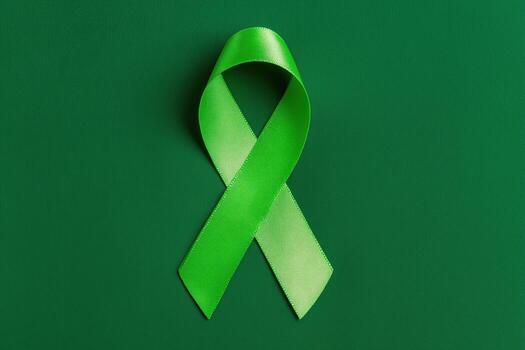 A vivid green awareness ribbon, signifying various causes, set against a complementary green background. photo