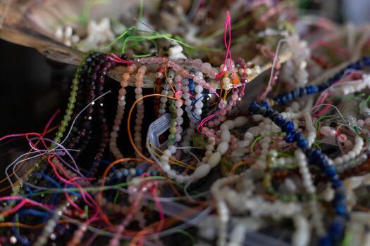 Colorful array of beads and threads displayed in handcrafted bowl at a local market photo