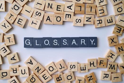 Glossary word in wooden cube blocks, alphabetical dictionary concept, collection of terms and definitions, education and reference idea photo