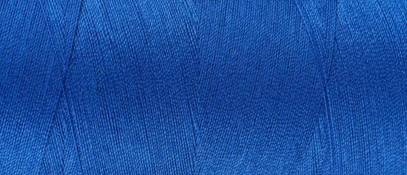 Texture of blue color threads in spool close up, macro. Wide banner, header photo