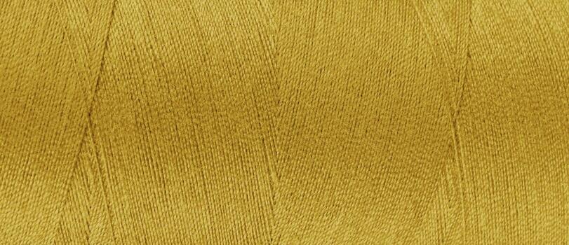 Texture of yellow color threads in spool close up, macro. Wide banner, header photo