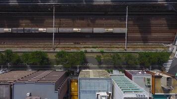 antenn se av tokyo som visar parallell tåg spår, en träd fodrad fotgängare väg, och modern byggnader med rör på sig skuggor tvärs över de scen. video