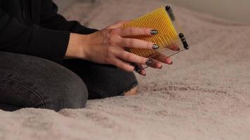 Hands manipulate a colorful pinart toy that rotates and forms unique shapes. This engaging activity offers a relaxing experience in a comfortable environment, ideal for creativity video