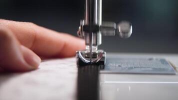 närbild av en sömnad maskin i handling, söm delikat tyg med invecklad mönster, highlighting de skicklighet och precision av de hantverk i en vibrerande arbetsyta. video