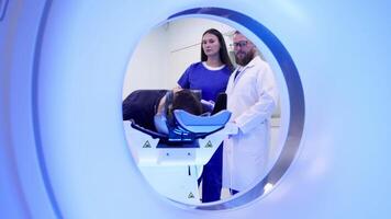 en man är placerad på de undersökning tabell av en modern mri maskin, redo för en medicinsk avbildning procedur i en rena, Avancerad sjukvård miljö. video