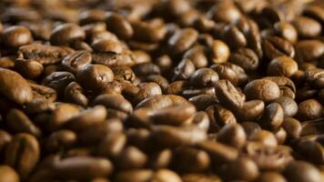 rostad kaffe bönor rotera i makro närbild, som visar glansig textur och mörk yta. kaffe rörelse skapar premie visuell till förbättra produkt överklagande. begrepp av kaffe rotation som branding bakgrund video