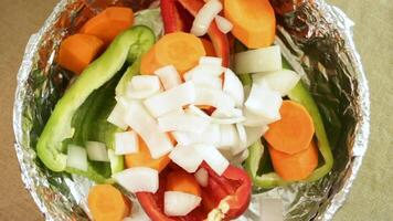 Chopped onion falls over layered carrot and pepper, each onion piece adding sharp texture. Onion slices contrast with other vegetables. Concept of onion layering in food preparation video