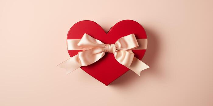 Festive box in the shape of a heart with a bow on a pink table. Banner with place for text, copy space for Valentine's day, mother's day and date. Romantic background with copy space photo