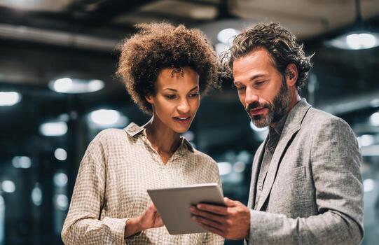 A man and woman looking at a tablet computer photo