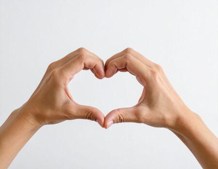 Hands making heart shape with finger on white background photo