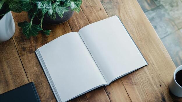 A book is open on wooden table with a potted plant next to it. The book is white and the table is made of wood photo