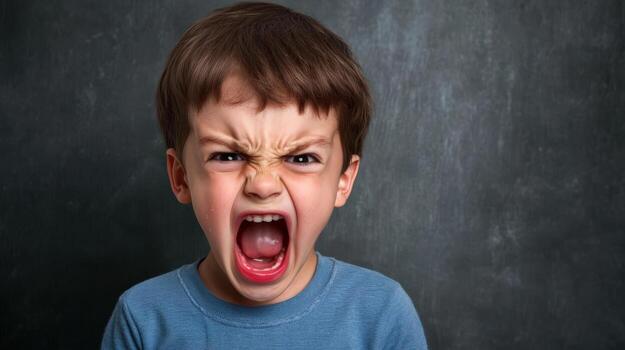 a young boy with his mouth open and an angry expression photo