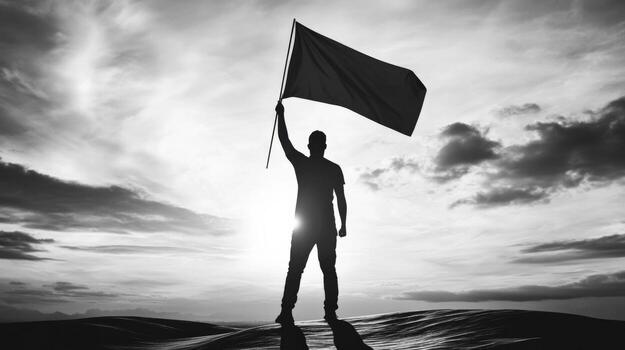 man holding up a black flag on a hill photo