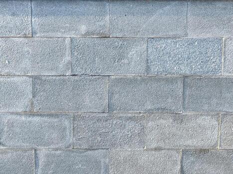 This image features a detailed close up of a weathered gray brick wall, showcasing the unique texture and patterns of the bricks used photo