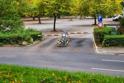 Parking Lot Entrance with Barrier Gate in Autumn Park Setting, Surrounded by Vibrant Yellow Trees and Green Bushes with Clear Road and Parking Sign for Urban Landscape Photography photo