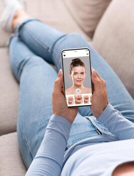 Augmented Reality Beauty App. Over The Shoulder View Of Lady Trying Different Lipstick Color Online On Smartphone, Using Modern Application With AR Makeup Simulation, Creative Collage, Selective Focus photo