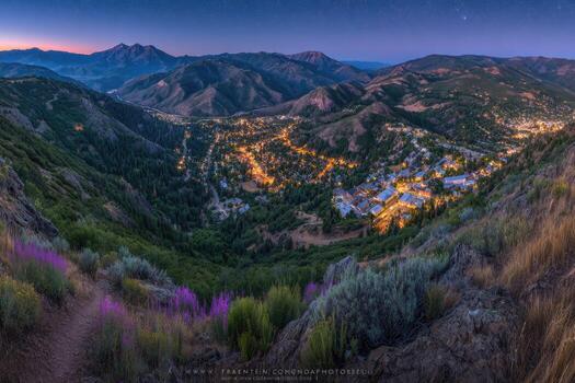 noche ver de iluminado residencial zona anidado en un montaña Valle debajo un estrellado cielo foto