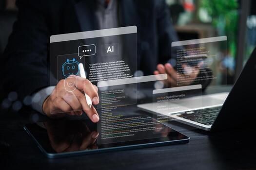 A man using a tablet with a digital interface and a laptop with a digital interface photo