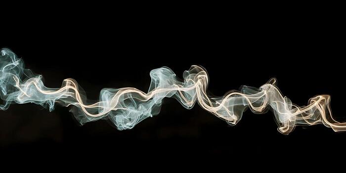 Dynamic white smoke creates an abstract wavy pattern against a dark background photo