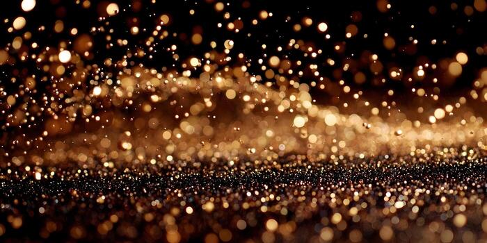 Golden glitter particles fall and sparkle on a dark abstract background creating a luxurious bokeh effect photo