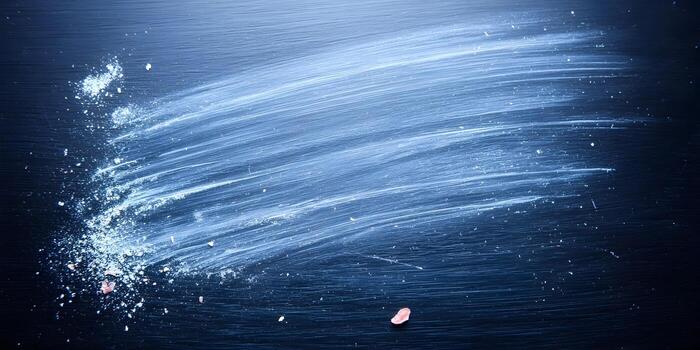 Dark blue background texture with white powder creating a dynamic diagonal swipe and scattered particles photo