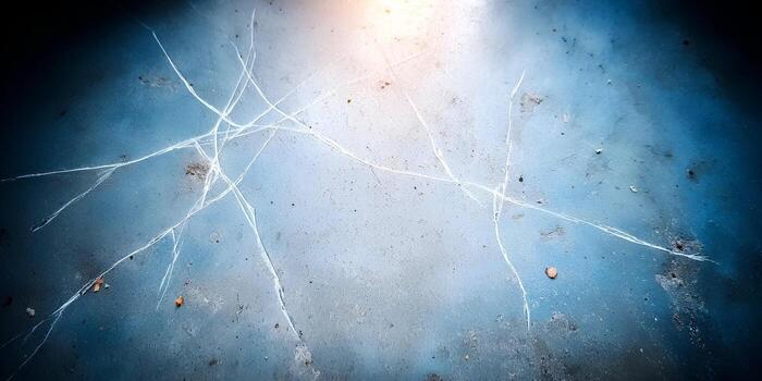 A close up view shows a pattern of cracks on a frozen ice surface with light reflecting from above photo