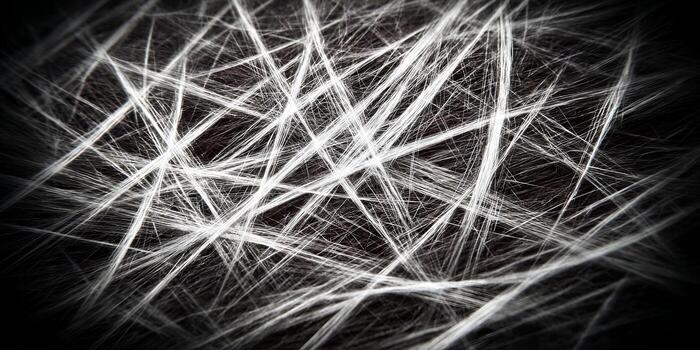 Luminous white lines form a dynamic abstract tangled pattern on a dark background creating a textured visual effect photo