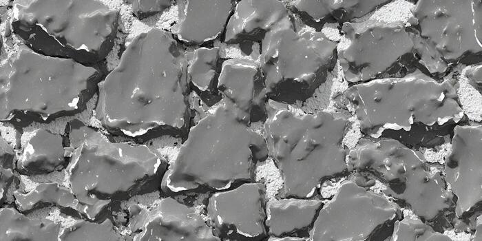 A monochrome overhead view of irregular dark grey rocks embedded in light grey granular material creating a rough texture photo