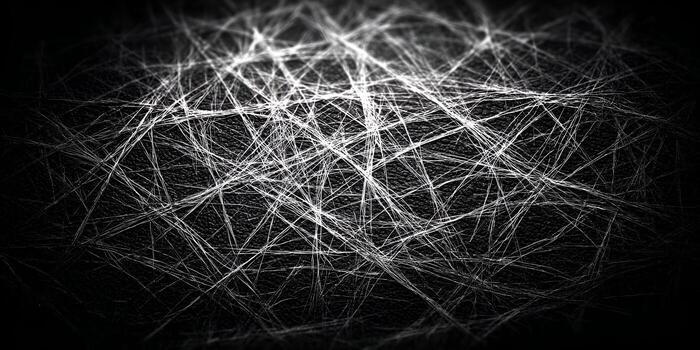 White abstract scratches create a tangled web design on a dark black textured surface photo