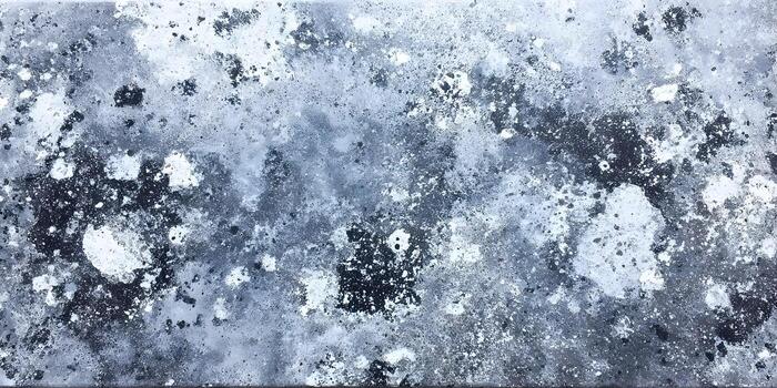 A close up view of a distressed grey stone texture with white and black splotches creating an abstract grunge background photo
