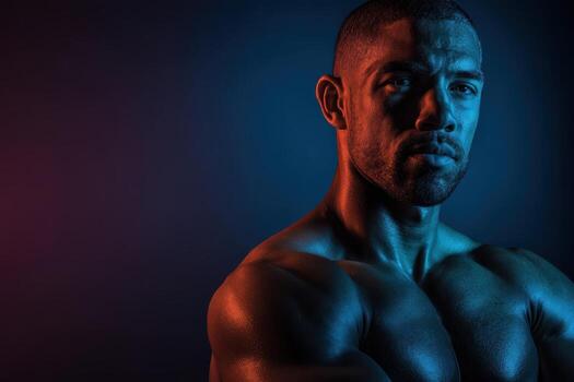 Muscular man with bare torso shown in red and blue lighting, creating dramatic shadows. The image captures the strength and seriousness of the subject with intense focus photo