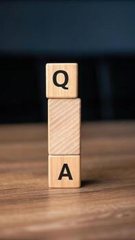 Wooden blocks stacked with the letters q and a photo