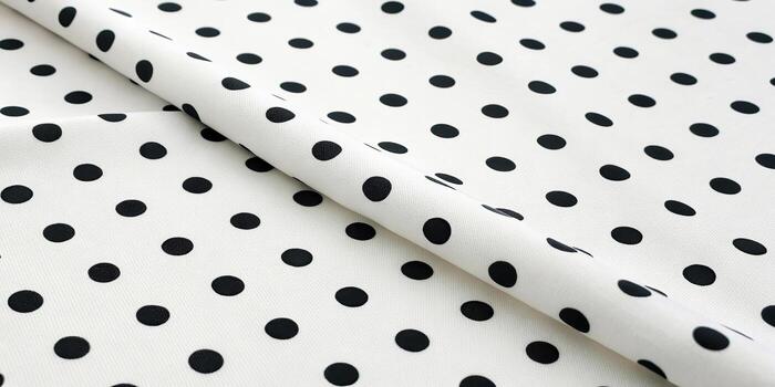Close up of white fabric with black polka dots photo