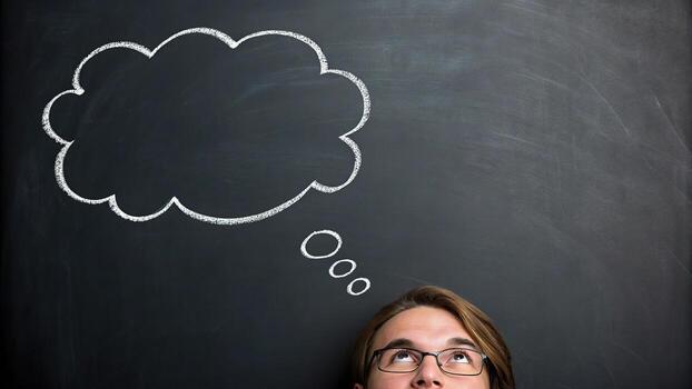 Man with thought bubble on blackboard photo