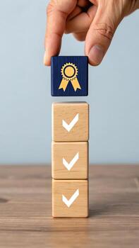 Hand placing wooden block with quality symbol on top photo