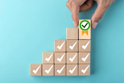 Hand placing last block with checkmark on stair graph photo