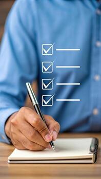 Hand with pen checking off list on notepad photo