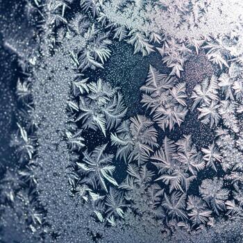 Frost Patterns on Glass with Sunlight Creating Sparkling Winter Abstract Scene photo