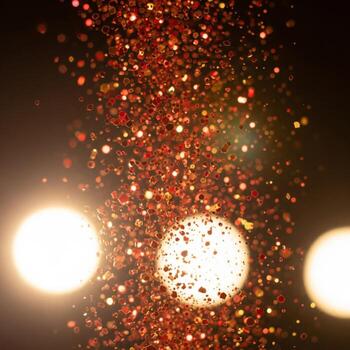 Elegant Orange Glitter Particles Floating in Dark Background with Bokeh Effect photo