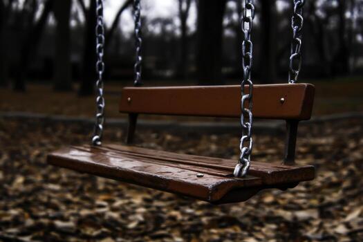 Red Swing Set in Autumn Park with Fallen Leaves and Overcast Sky Background photo