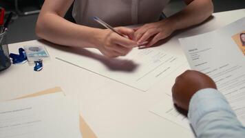 stänga upp av jobb sökare signering en arbete kontrakt efter framgångsrik intervju, sökande granskning Rättslig villkor av sysselsättning innan signerad avtal. onboarding bearbeta för ny början. kamera a. video