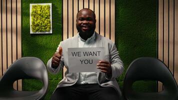 svart företag person från de anställa team visning annons baner främja öppen positioner, arbetsplats inkludering och förtroende i talang rekrytering. tillgängliga placera. kamera a. video